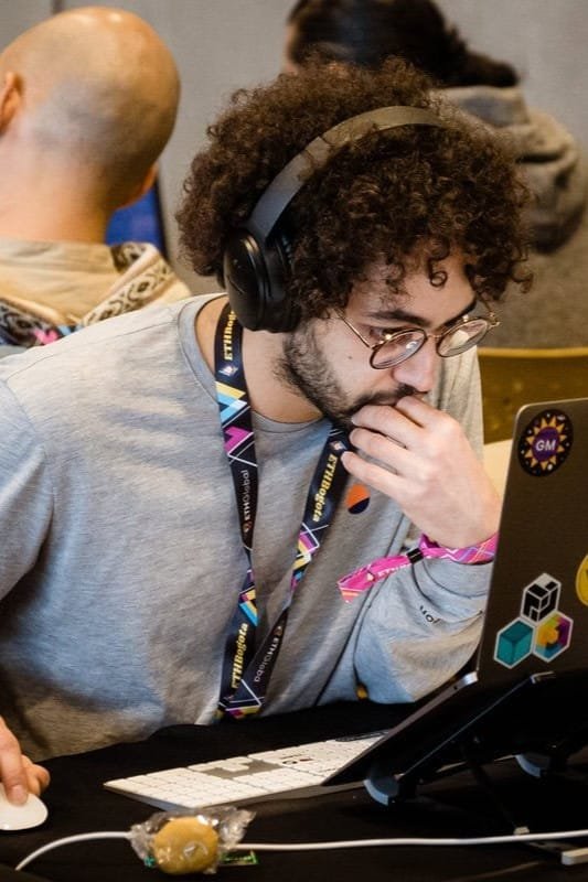 Participante concentrado en un evento corporativo, trabajando en su laptop.