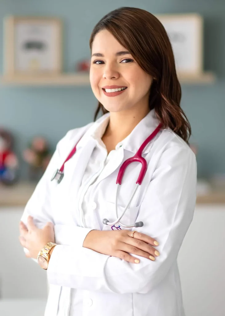 Médico sonriente en un entorno profesional con estetoscopio al cuello.