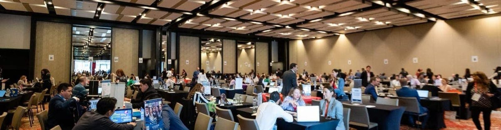 Vista general de un evento corporativo, lleno de emoción y charlas entre participantes. Vista general de un evento corporativo, lleno de emoción y charlas entre participantes.